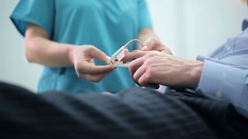 Nurse Puts a Pulse Oximeter on Finger