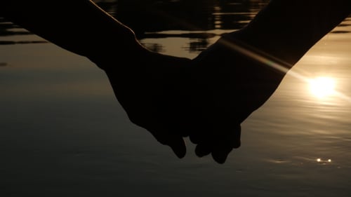 Silhouette of Couple Holding Hands at Sunset