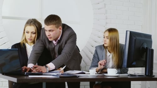 A Man And Two Women Working In a Modern Office