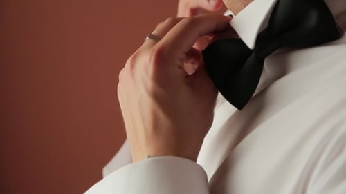 Man Adjusting Bow Tie Before Wedding Ceremony