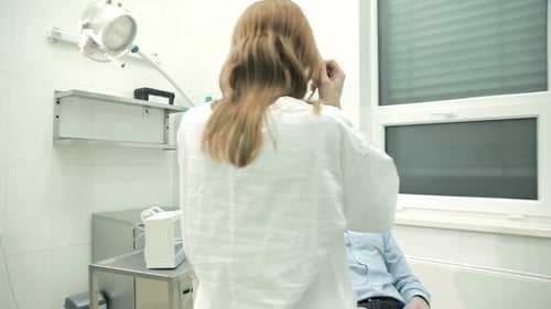 Doctor Listens to Patient Heart with Stethoscope