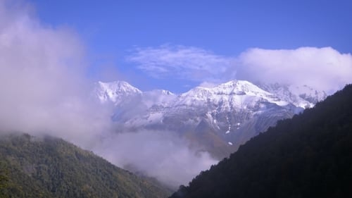 Snowy Mountain Peaks Over Green Landscape