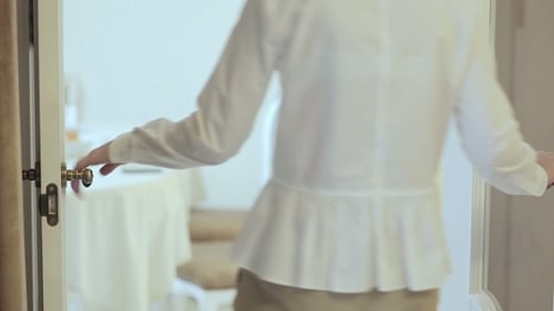 Woman Opens Glass Doors to Bright Room