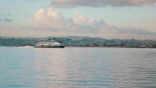 Ferry-Katamaran segelt auf einem Hintergrund der Stadt