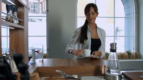 Woman Enjoying Coffee in a Bright Kitchen