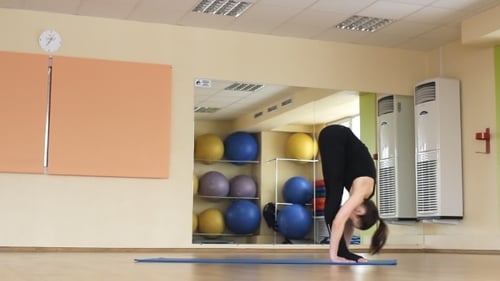 Woman Performing Yoga Sequence in Bright Gym