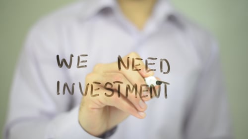 Writing We Need Investment on Clear Surface