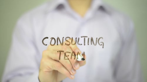 Hand Writes Consulting Team with Black Marker