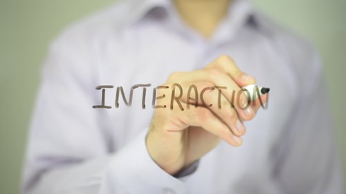 Man Writes Interaction on Clear Surface With Marker