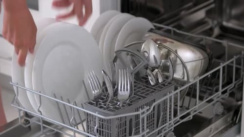 Close Up Woman Taking Out Clean Dishes From Dishwasher