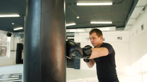 MMA Fighter Boxers Doing Some Training on a Punching Bag at a Gym Close Up Power Punch Kicks Macro