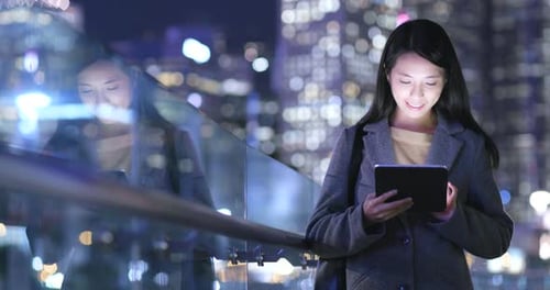 Woman Using Tablet at Night in City