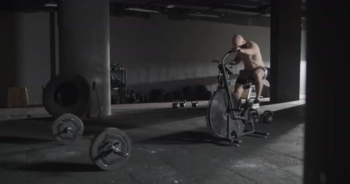 Man Exercising on Stationary Bike in Gym