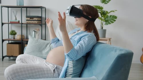 Side View of Pregnant Woman Wearing Virtual Reality Glasses Moving Hands and Smiling