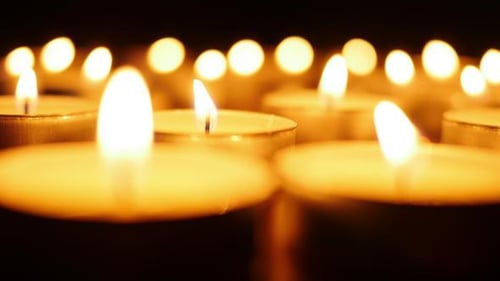 Many Tealight Candles Glowing in the Dark