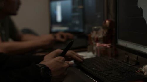Men Working at Computers in Dimly Lit Room