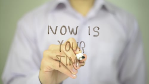 Person Writes "Now Is Your Time" with Marker