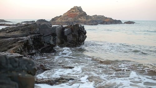 Waves Crashing on Rocky Beach at Sunset