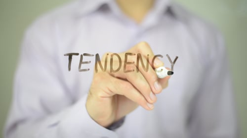Adult Writing the Word Tendency With Marker