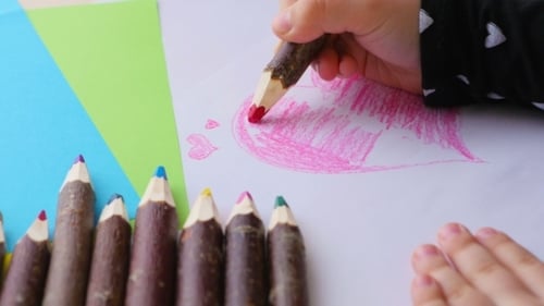 Mädchen malt Herz mit Bleistift