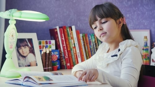 Girl Reading a Book at Her Desk