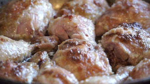Close Up Of Chicken Thighs Cooking In Pan