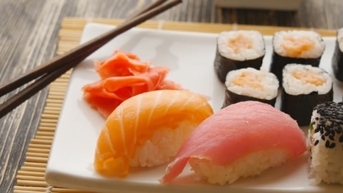 Various Sushi On White Plate On Wooden Background