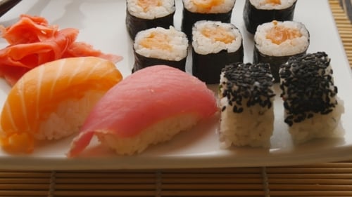 Various Sushi On White Plate On Wooden Background