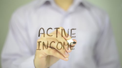 Hand Writing Active Income on Clear Surface