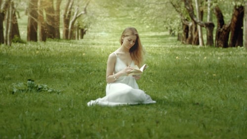 Woman Reading Book in Peaceful Grassy Meadow