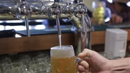 Bartender Pouring Draft Beer into Glass Mug