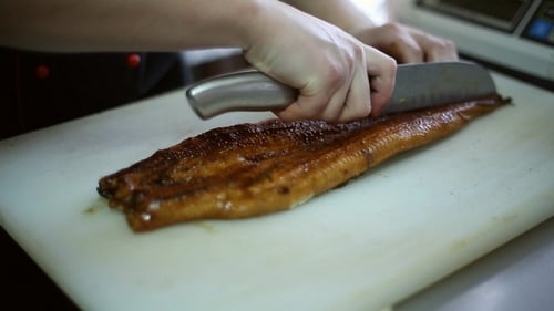 Chef Cutting Cooked Eel for Fine Dining