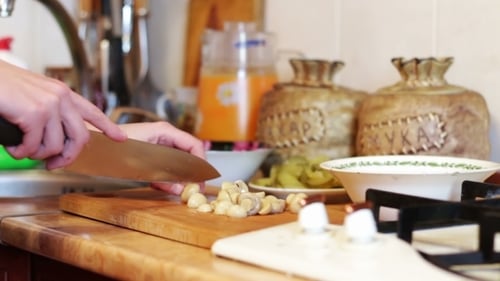 Hands Chopping Fresh Mushrooms in a Kitchen