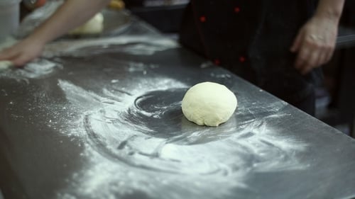 Chef Rolling Dough on a Floured Counter