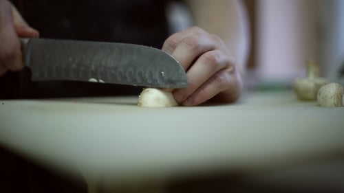 Expertly Slicing Fresh Mushrooms on Cutting Board