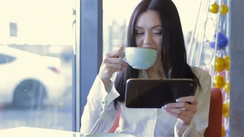 Woman Using Tablet in Cafe