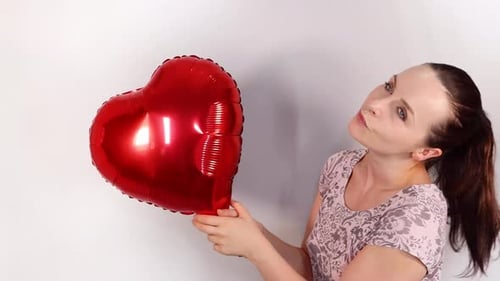 Smiling Woman Holding Red Heart Shaped Balloon