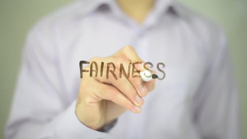 Man Writes Word Fairness on Glass Surface