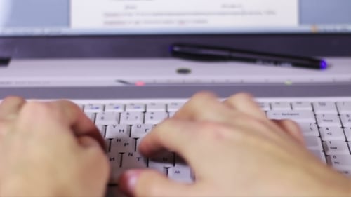 Hands Typing on Computer Keyboard at Workplace