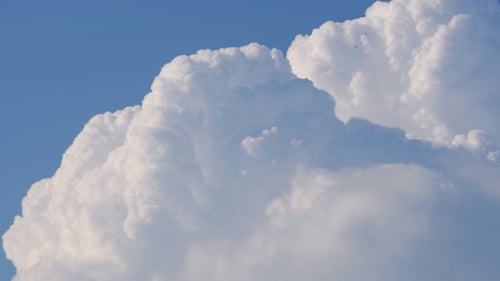 Clouds Drifting Across Clear Blue Sky
