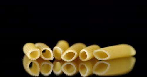 Close Up of Dry Pasta Tubes on Black