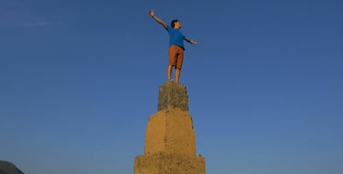 Young Adult Stands on High Rural Tower