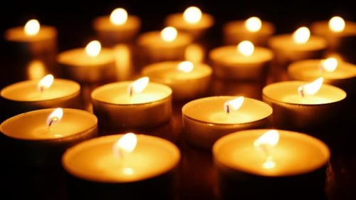 Many Tealight Candles Burning Brightly in the Dark