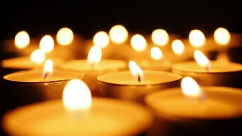 Many Tea Light Candles Softly Glowing in Dark