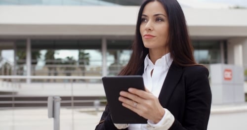 Focused Woman Uses Tablet Outside Office Building