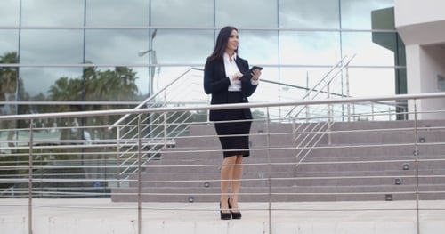 Businesswoman Using Tablet Outside Modern Office Building