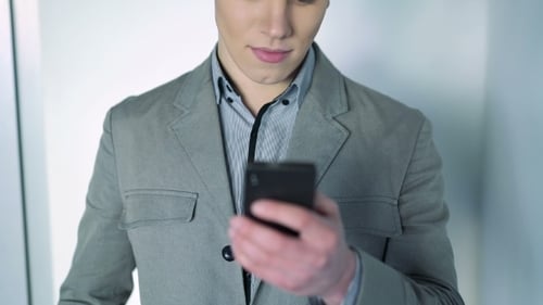 Handsome Boy Looks at Phone