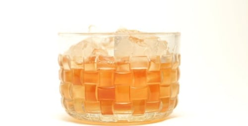 Pouring Whiskey into Glass with Ice Cubes