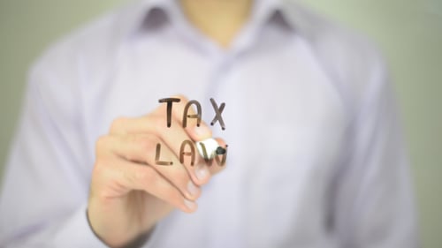 Hand Writing Tax Law on Glass