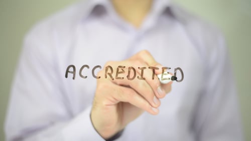 Hand Writes "Accredited" With Marker